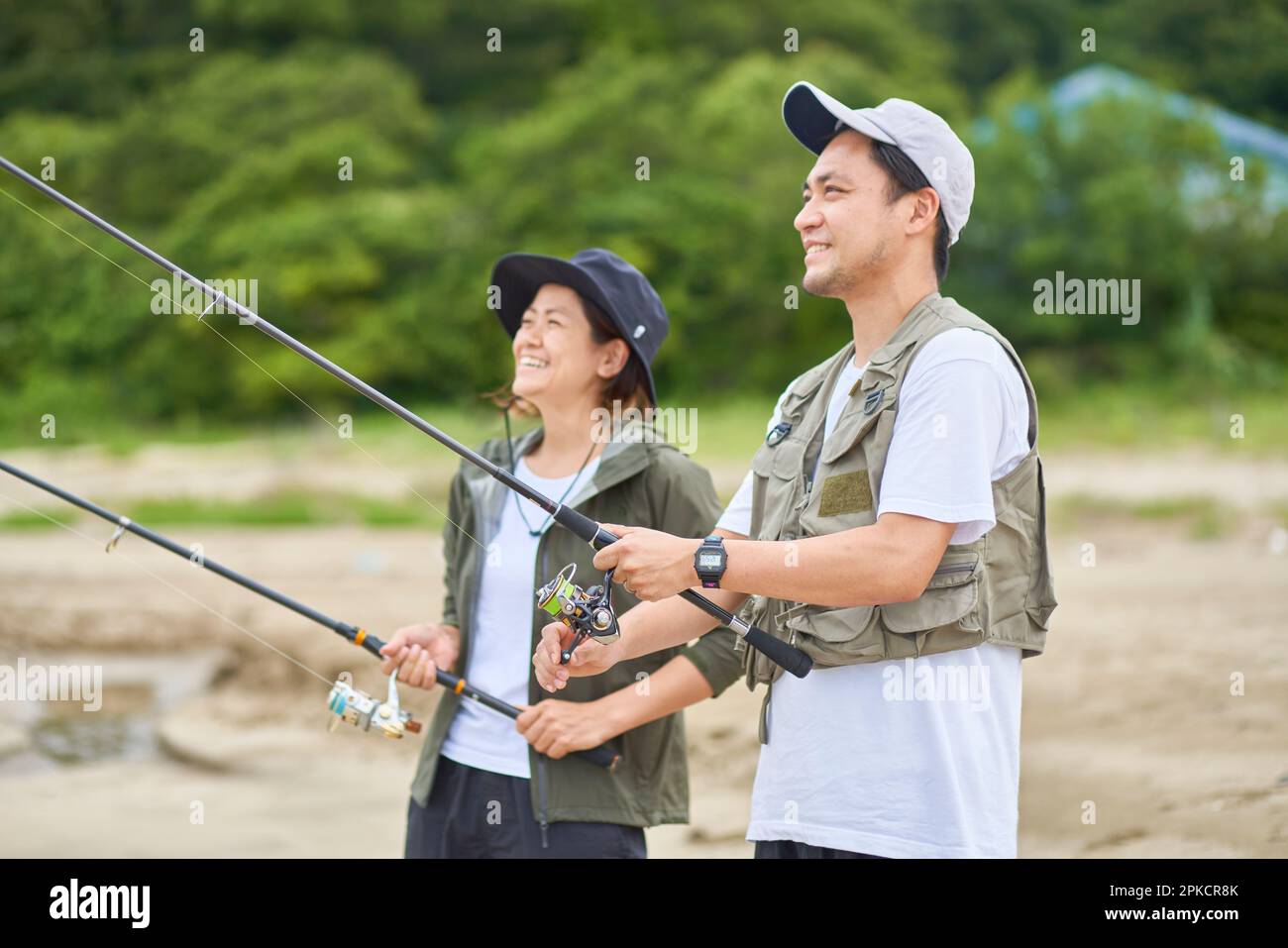 Man and woman fishing on the beach Stock Photo