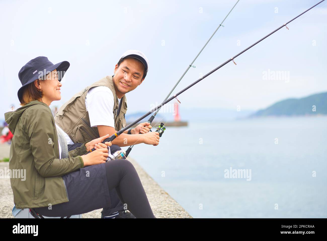 Man and woman sitting on the bank fishing Stock Photo