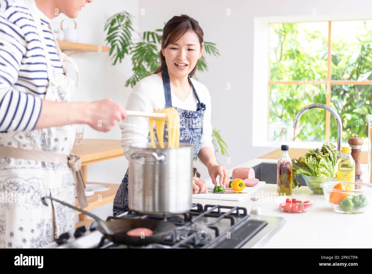 A couple in their 30s cooking in the kitchen Stock Photo