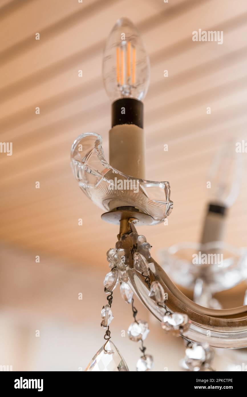 Broken glass chandelier in living room with a broken light arm with a