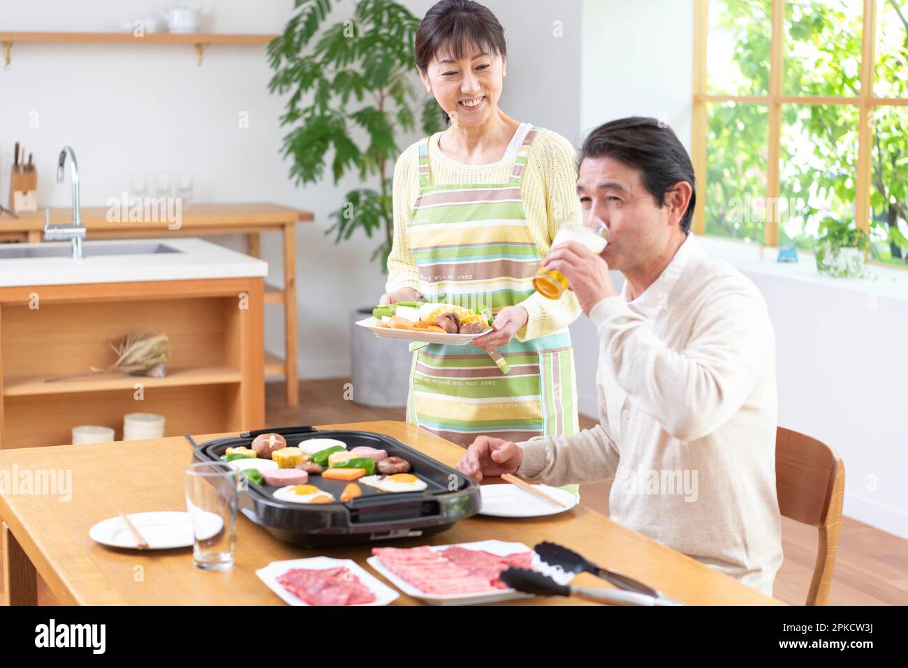 Middle-aged couple eating Yakiniku with draft beer Stock Photo