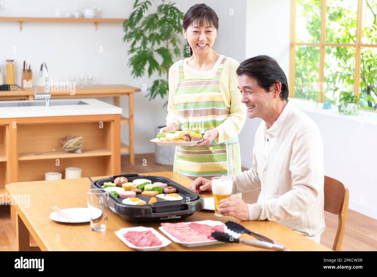 Middle-aged couple eating yakiniku with draft beer Stock Photo
