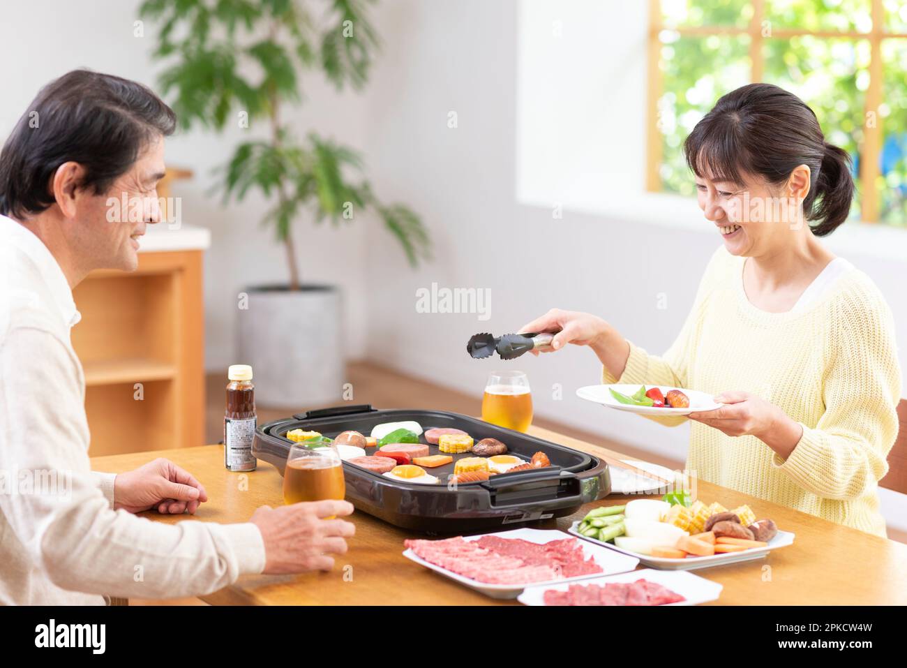 A middle-aged couple eating Yakiniku with draft beer Stock Photo