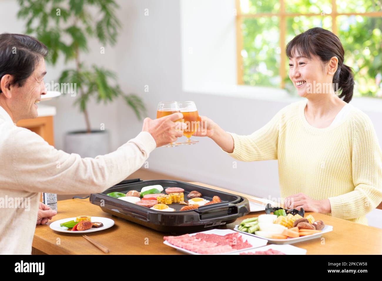 A middle-aged couple eating Yakiniku with draft beer Stock Photo