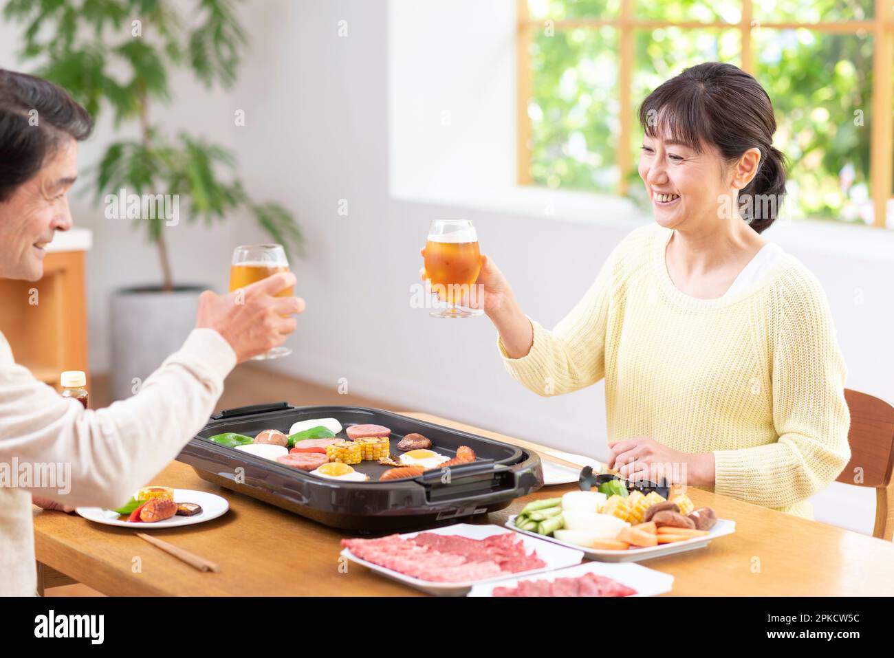 A middle-aged couple eating Yakiniku with draft beer Stock Photo
