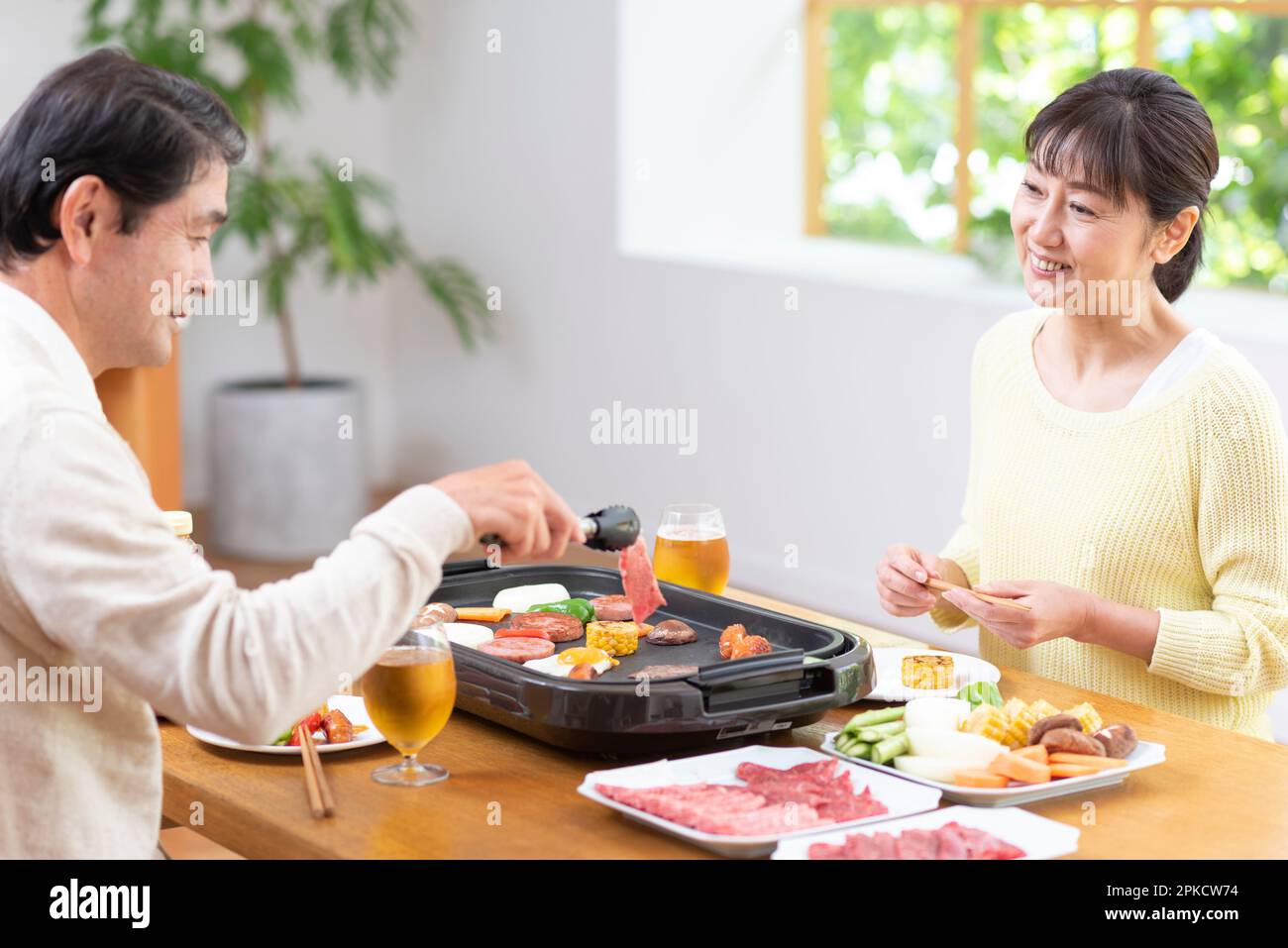 A middle-aged couple eating Yakiniku with draft beer Stock Photo