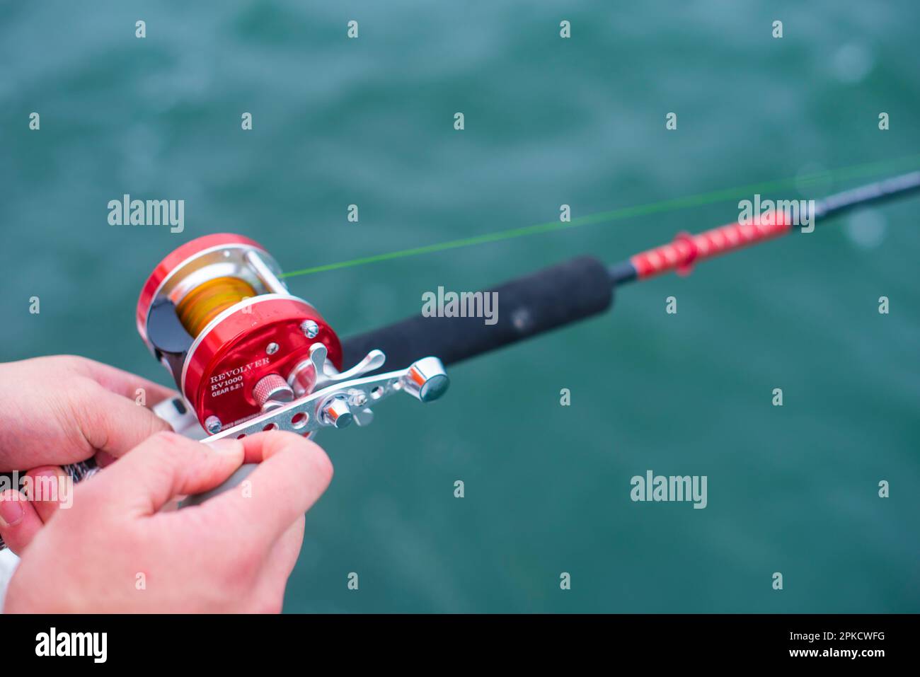 Woman holding fishing rod with one hand hires stock photography and