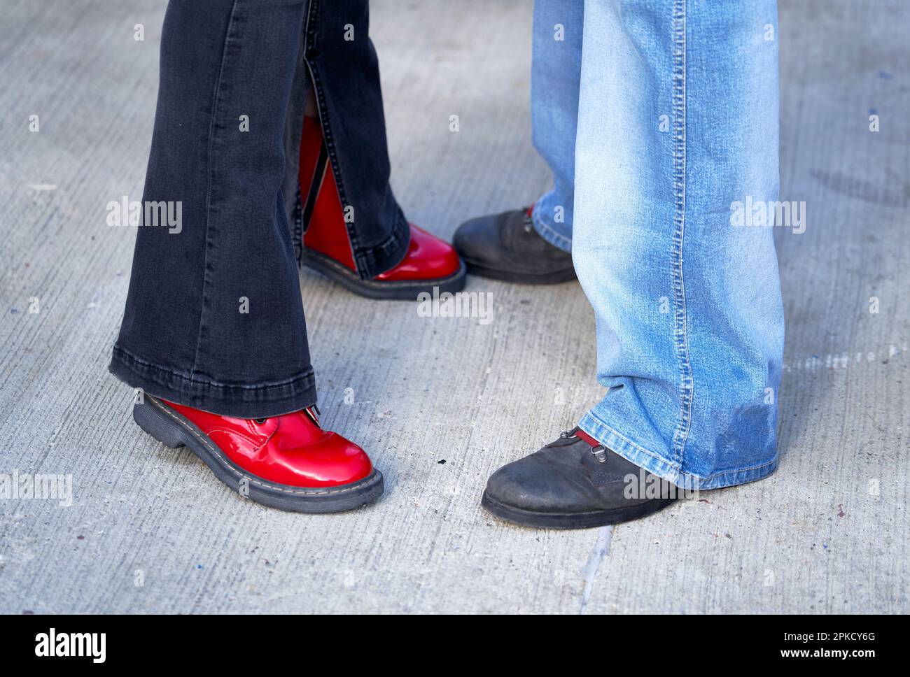 Man's and woman's feet in jeans and boots Stock Photo