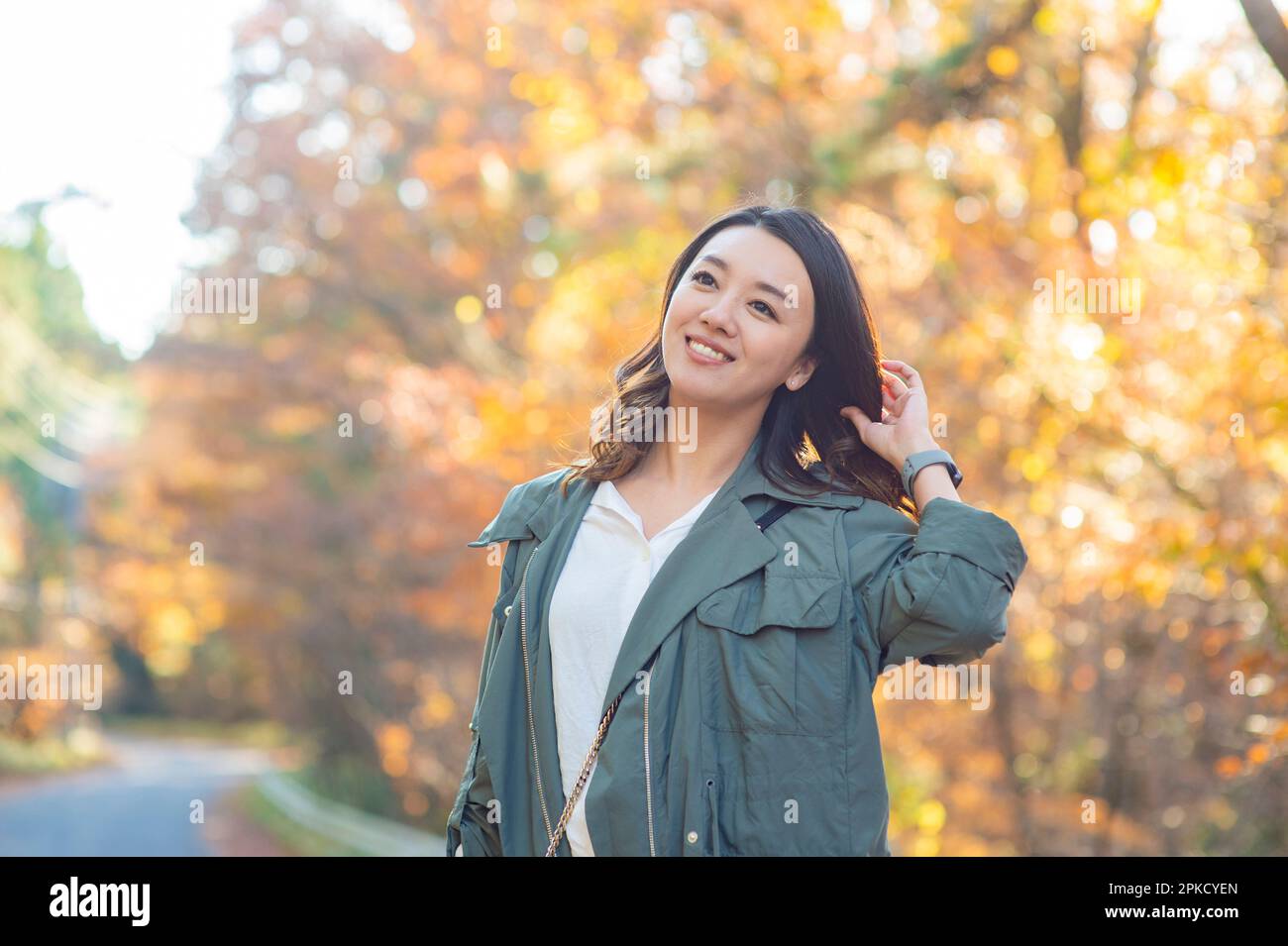 While Viewing A woman strolling in a sightseeing spot while viewing autumn leaves ...