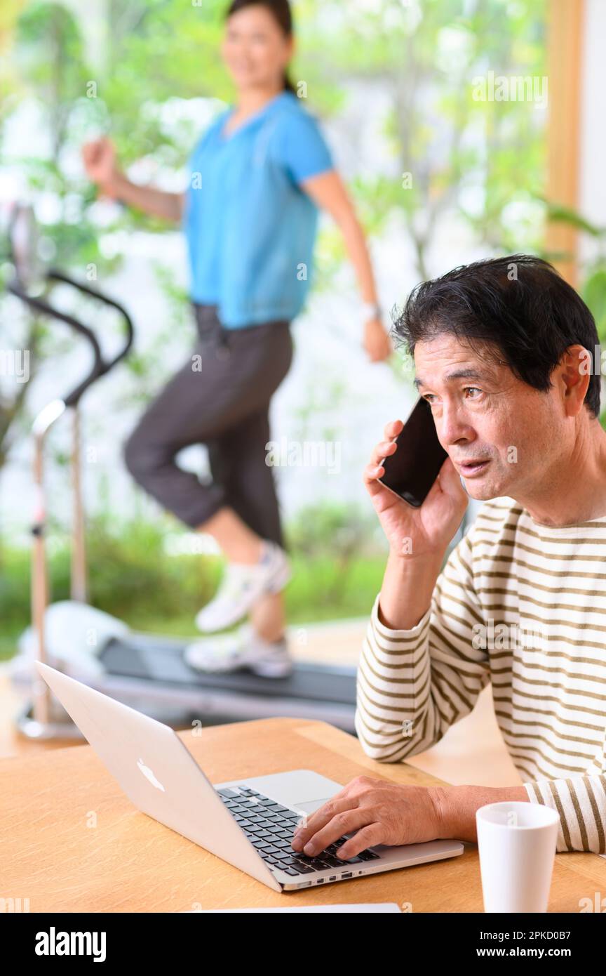 Teleworking middle-aged man and running machine Stock Photo
