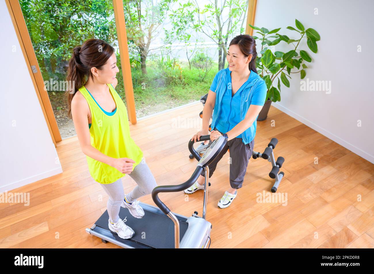 Mother and Daughter exercising with the machine in their own home Stock Photo
