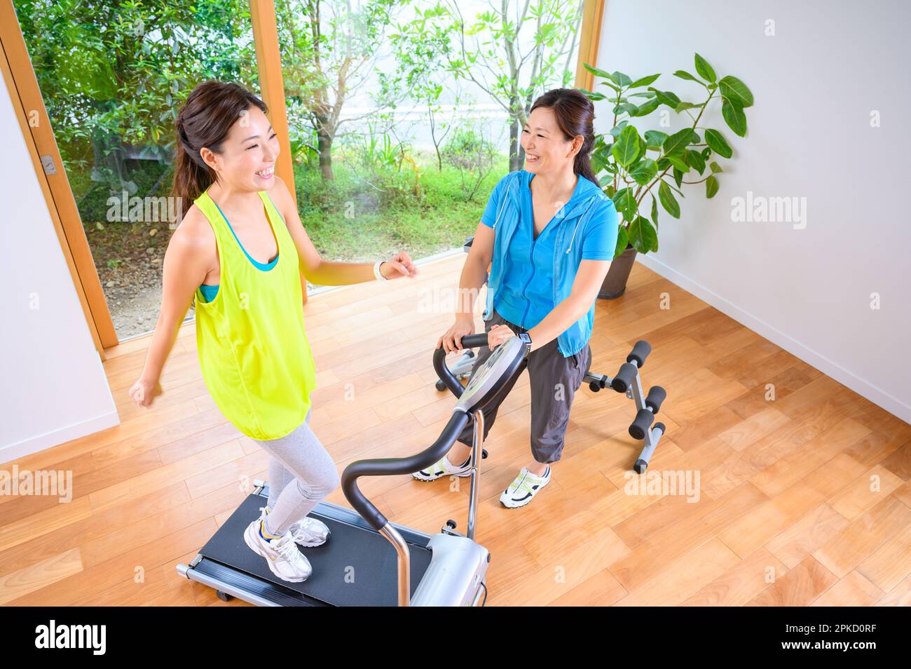 Mother and Daughter exercising with the machine in their own home Stock Photo