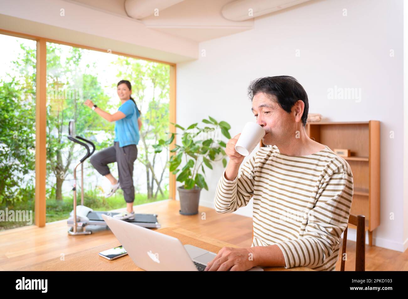 Teleworking middle-aged and older man with running machine Stock Photo