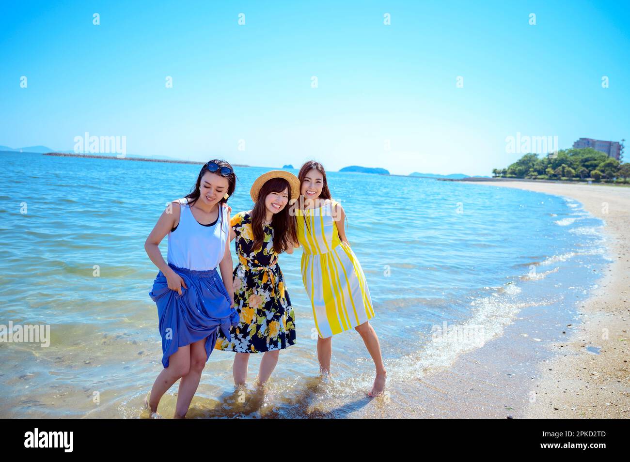 3 women traveling to a sea resort playing on the beach Stock Photo