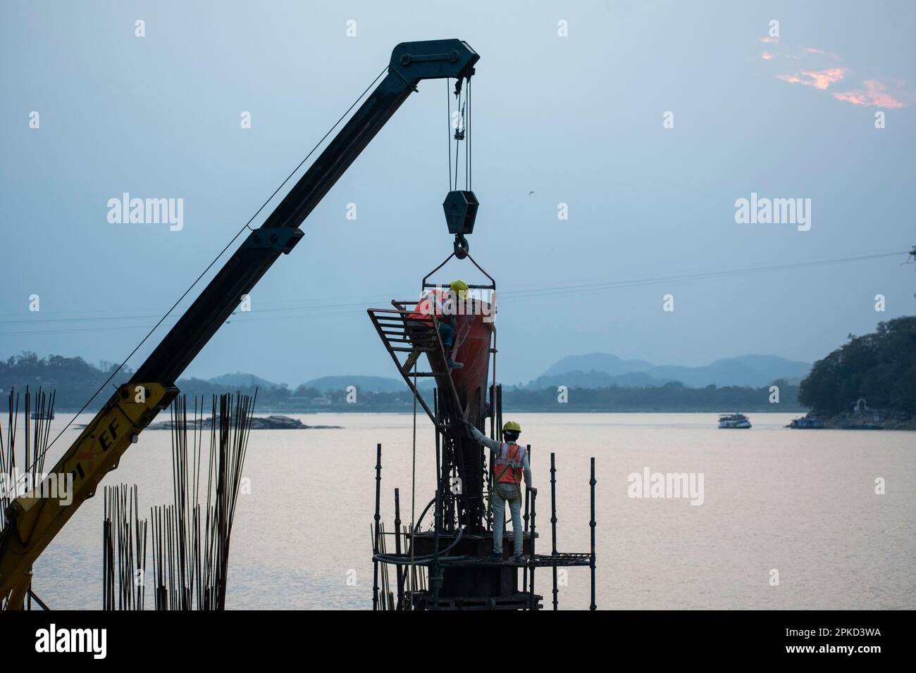 Construction workers busy build pillars of a bridge in the banks of ...