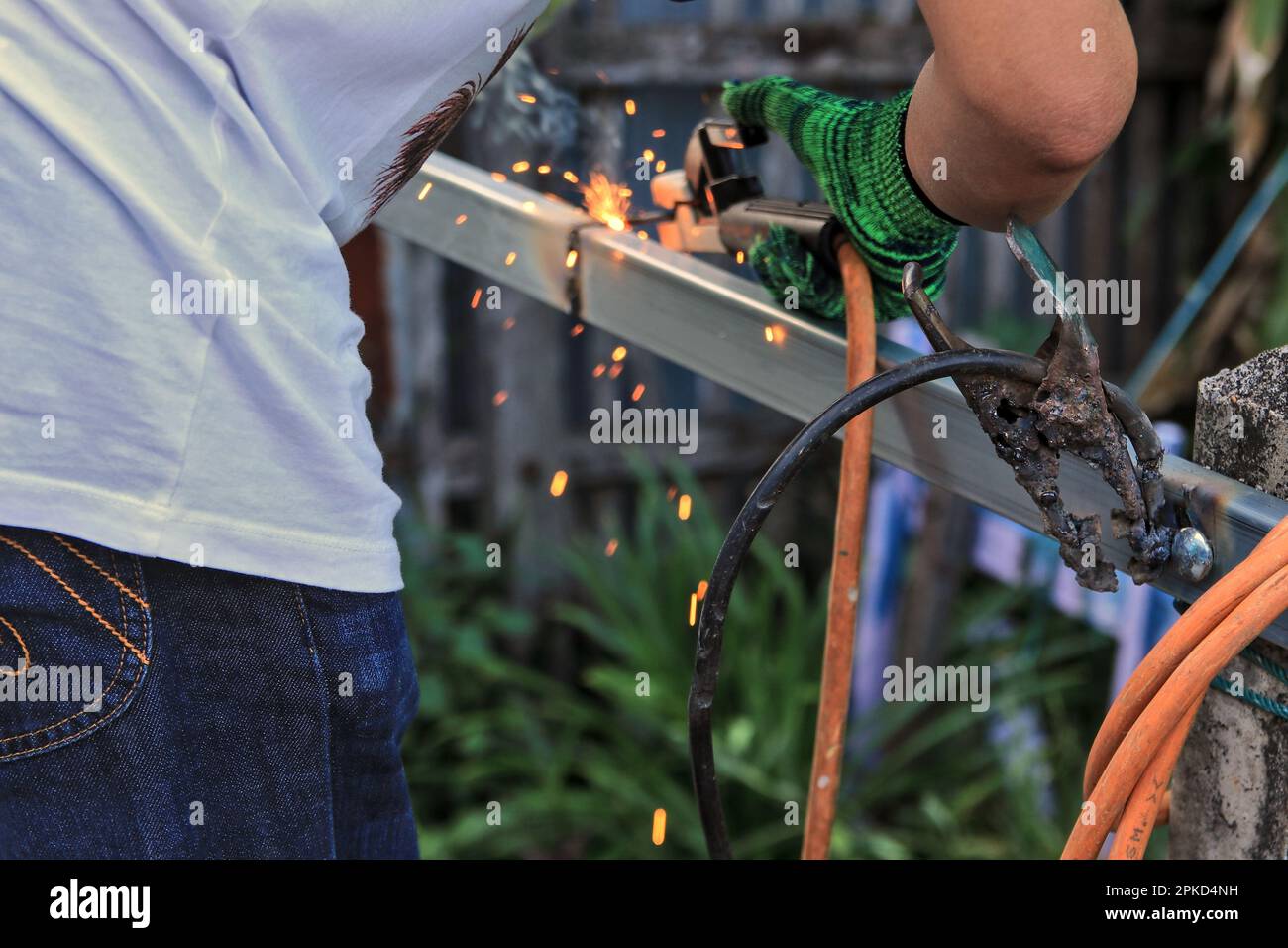 The butler is welding an iron fence. by using an electric welding machine where the ground wire is damaged But can be modified to use only on the page Stock Photo
