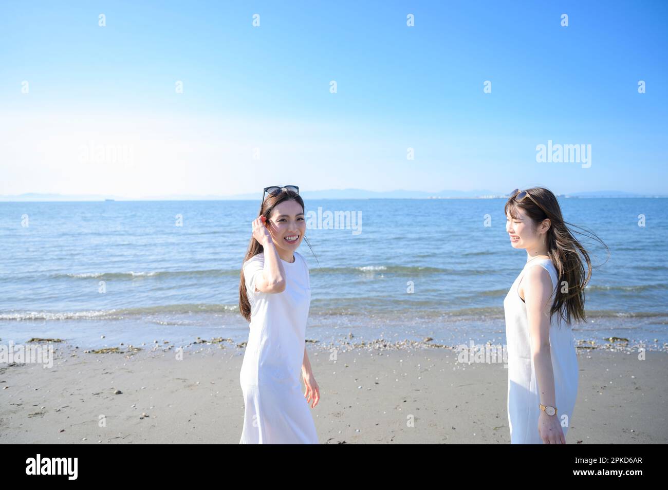 Two women walking on the beach Stock Photo