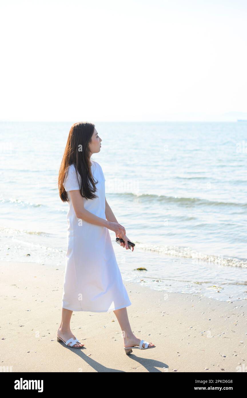 woman strolling along the seashore Stock Photo