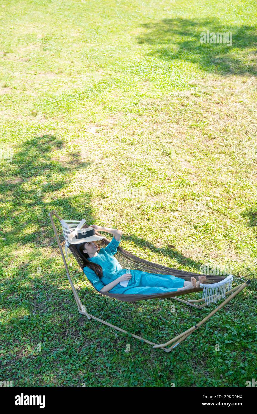 Woman lying in a hammock at a campsite in the highlands Stock Photo Alamy