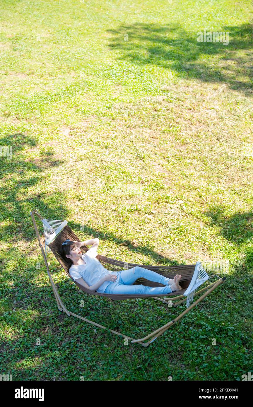 Woman lying in a hammock at a campsite in the highlands Stock Photo Alamy