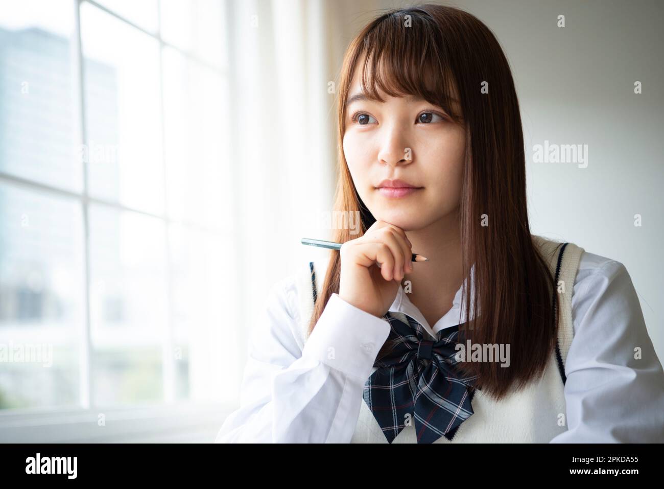High school girl holding a pencil Stock Photo - Alamy