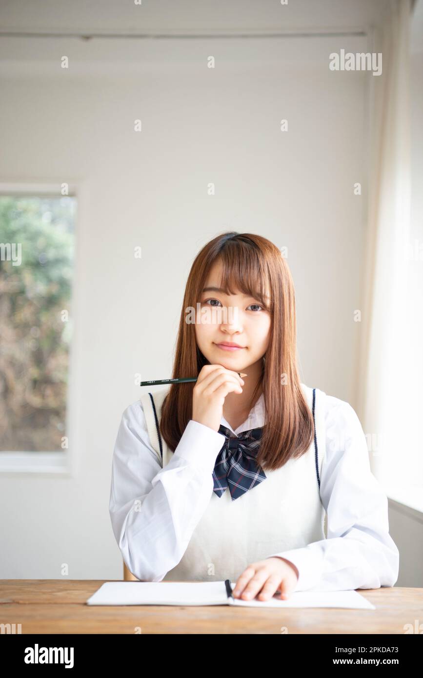 High school girl holding a pencil Stock Photo - Alamy