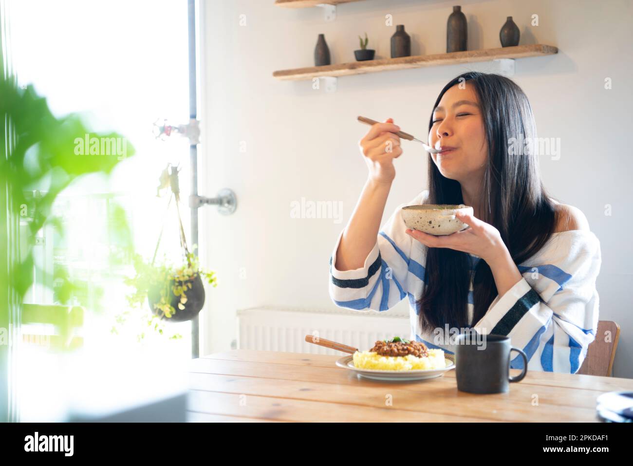 Woman eating food at the table Stock Photo