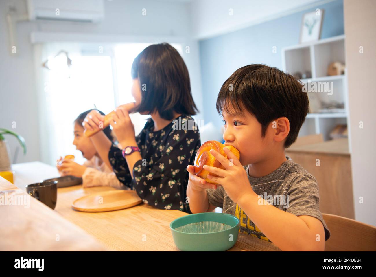 Children eating bread at the counter Stock Photo
