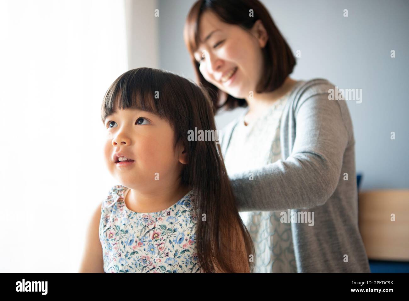 Mother combing girl's hair Stock Photo