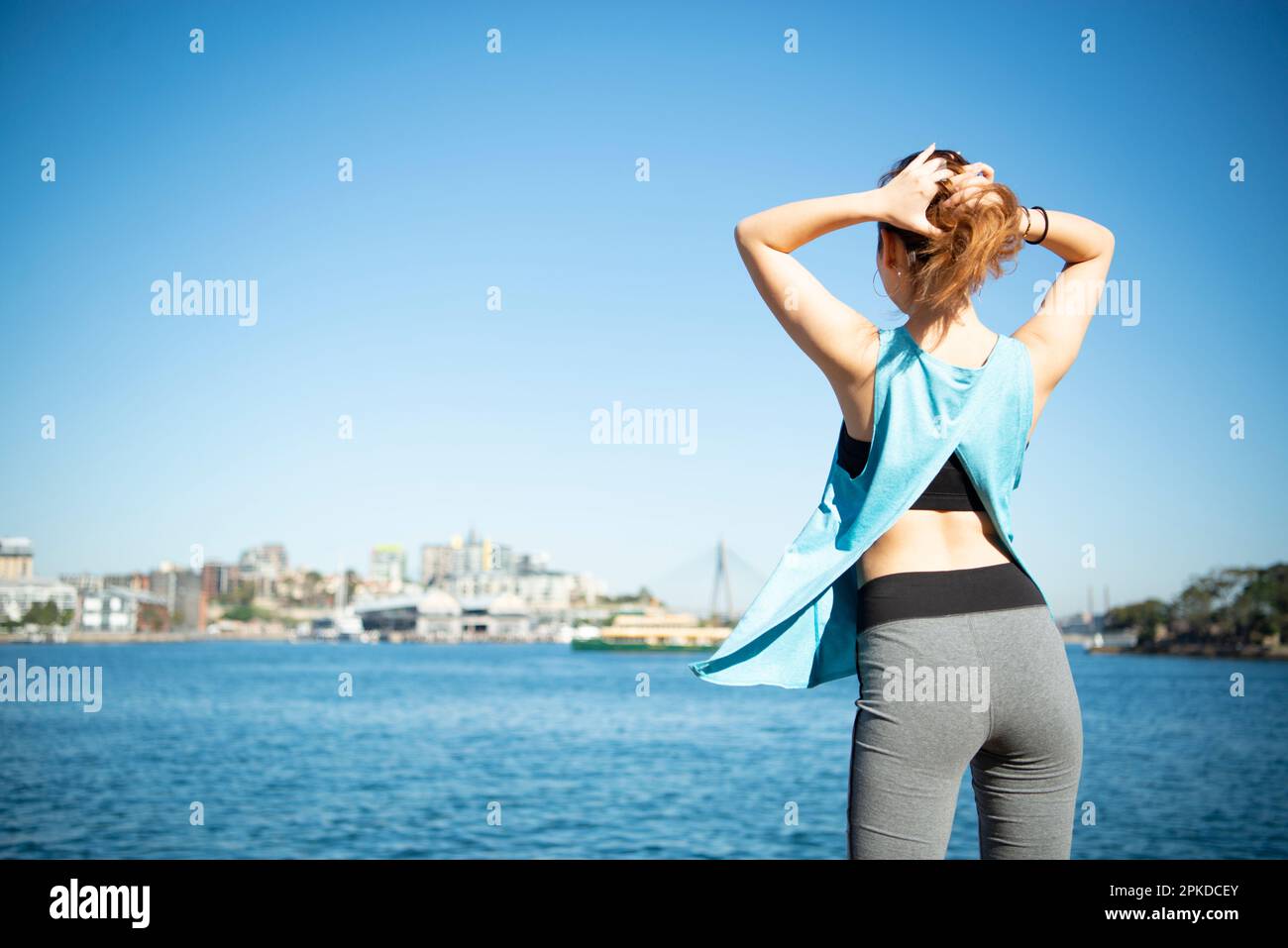 Back view of woman tying her hair while exercising Stock Photo