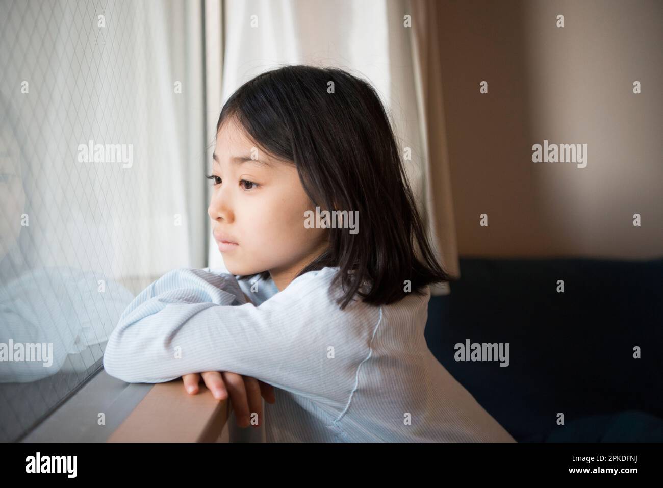 Girl looking out of window Stock Photo