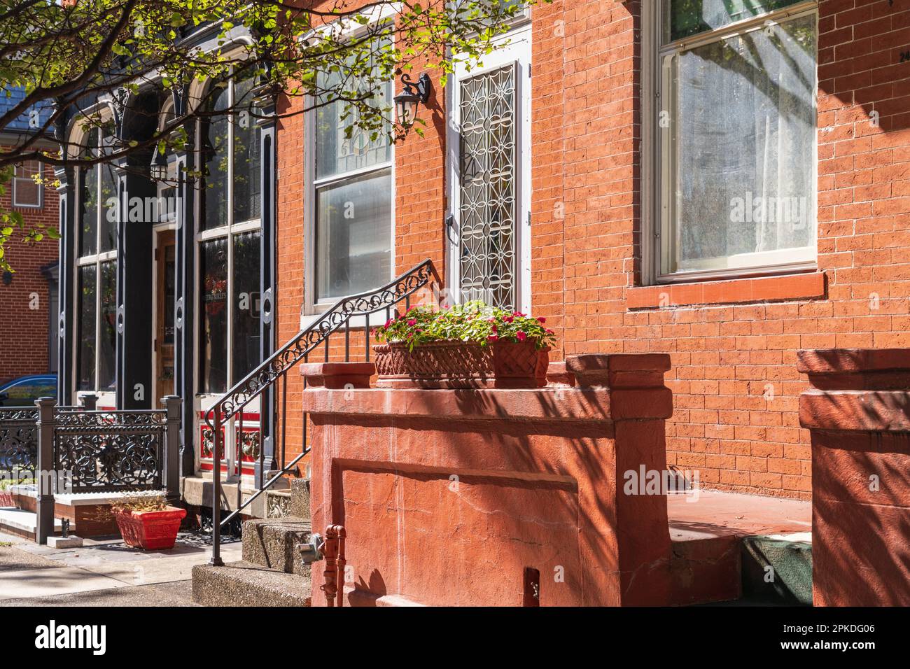 Red brick row houses and buildings with front stoops, decorative wrought iron and planters in Harrisburg, capital of Pennsylvania USA Stock Photo