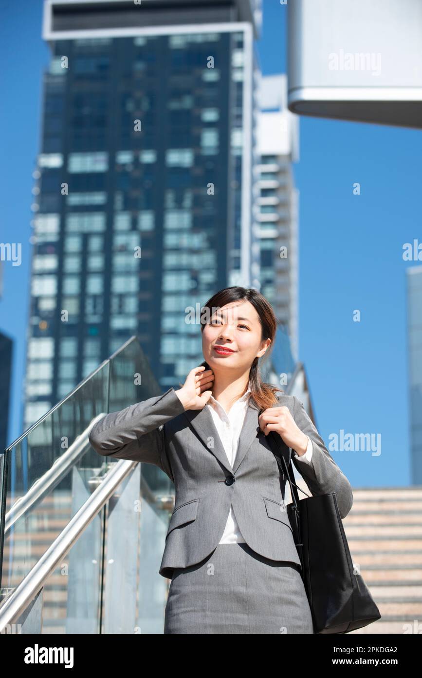 Woman in suit descending stairs Stock Photo