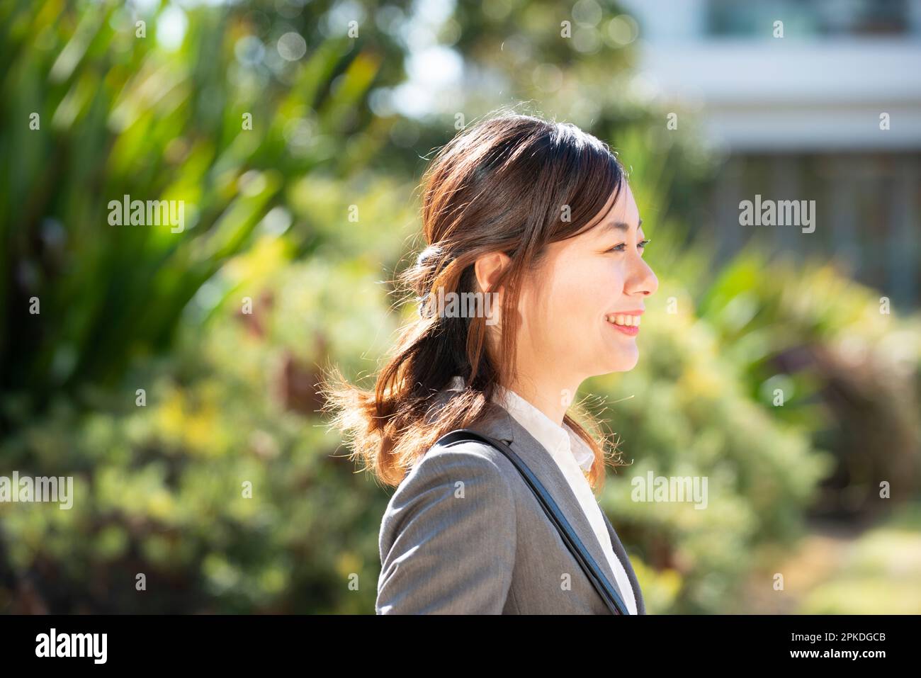 Profile of woman in suit smiling Stock Photo