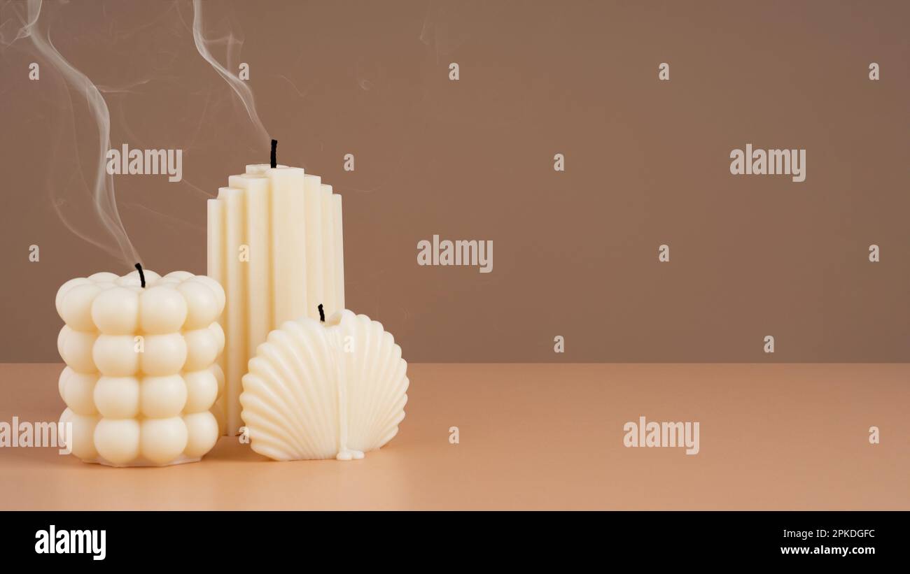 Handmade olive wax different forms candle with smoke from the wick on a