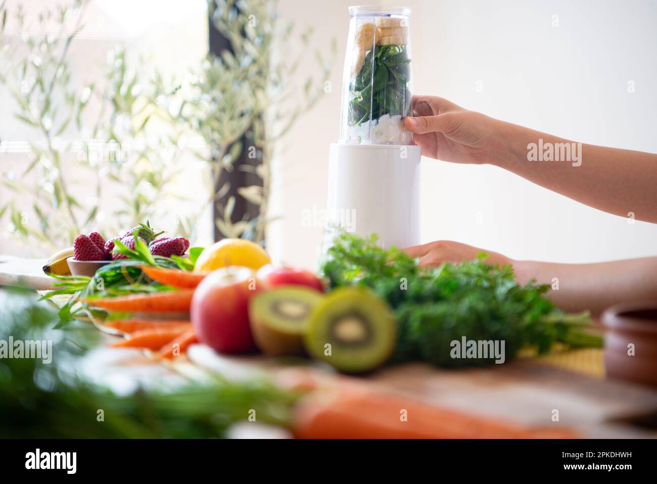 Woman loading ingredients for a smoothie into a blender Stock Photo Alamy