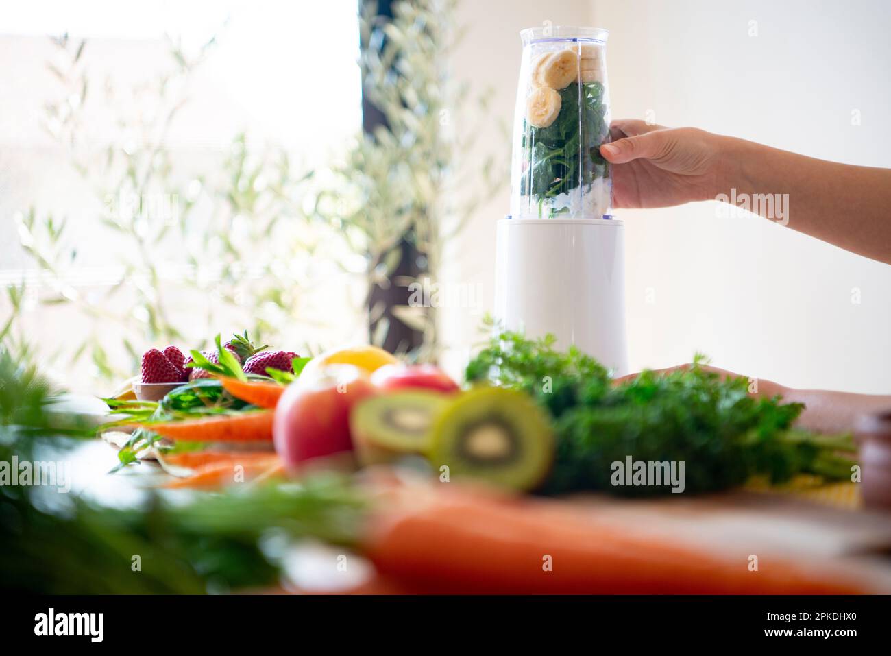 Woman loading ingredients for a smoothie into a blender Stock Photo Alamy