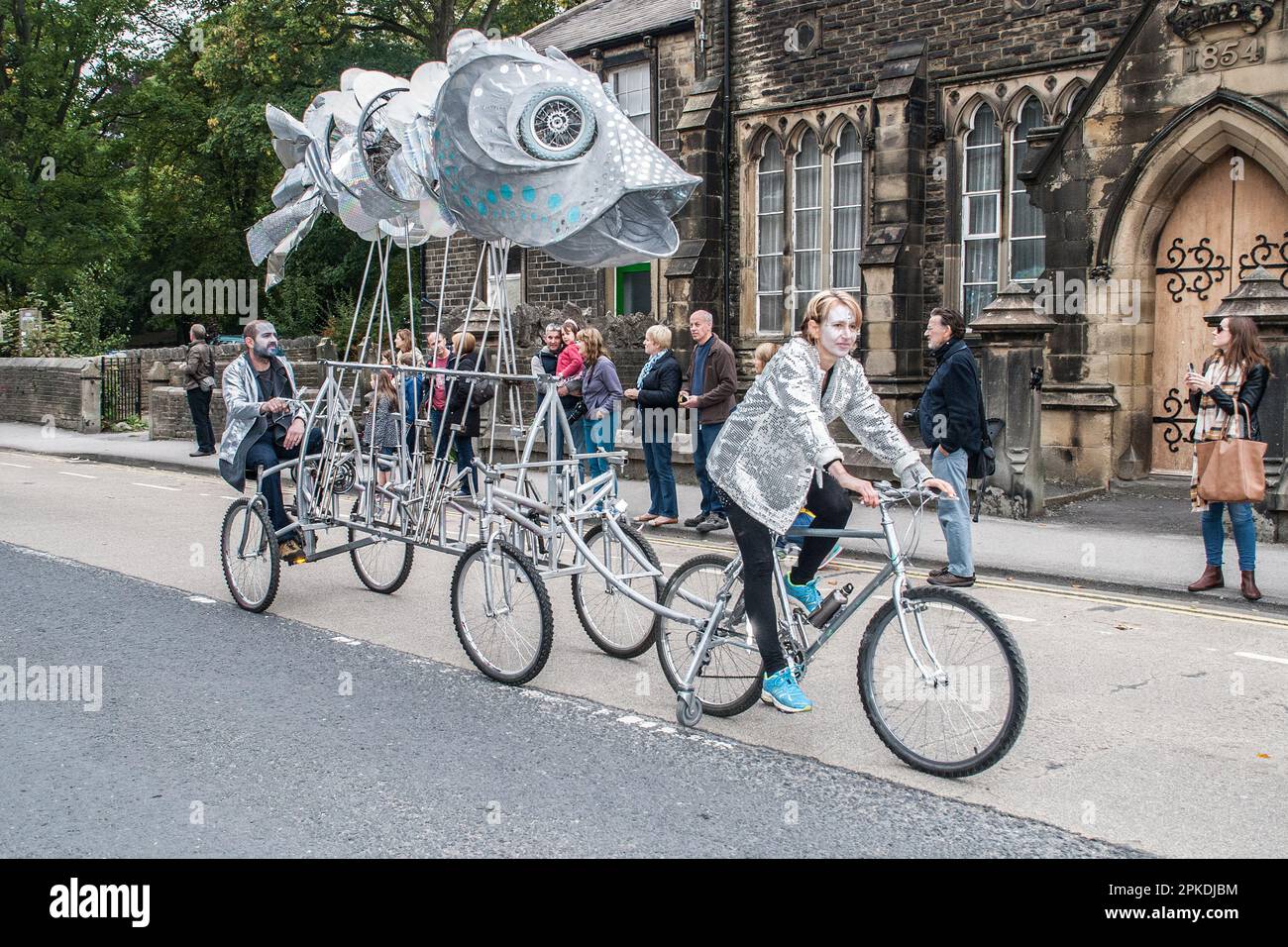 Giant fish is hauled by a cyclist in the street parade at the Skipton International Puppet Festival 2015 Stock Photo