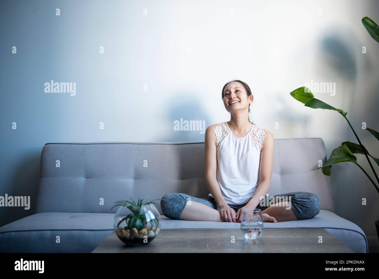 Woman sitting on sofa in living room hi-res stock photography and ...