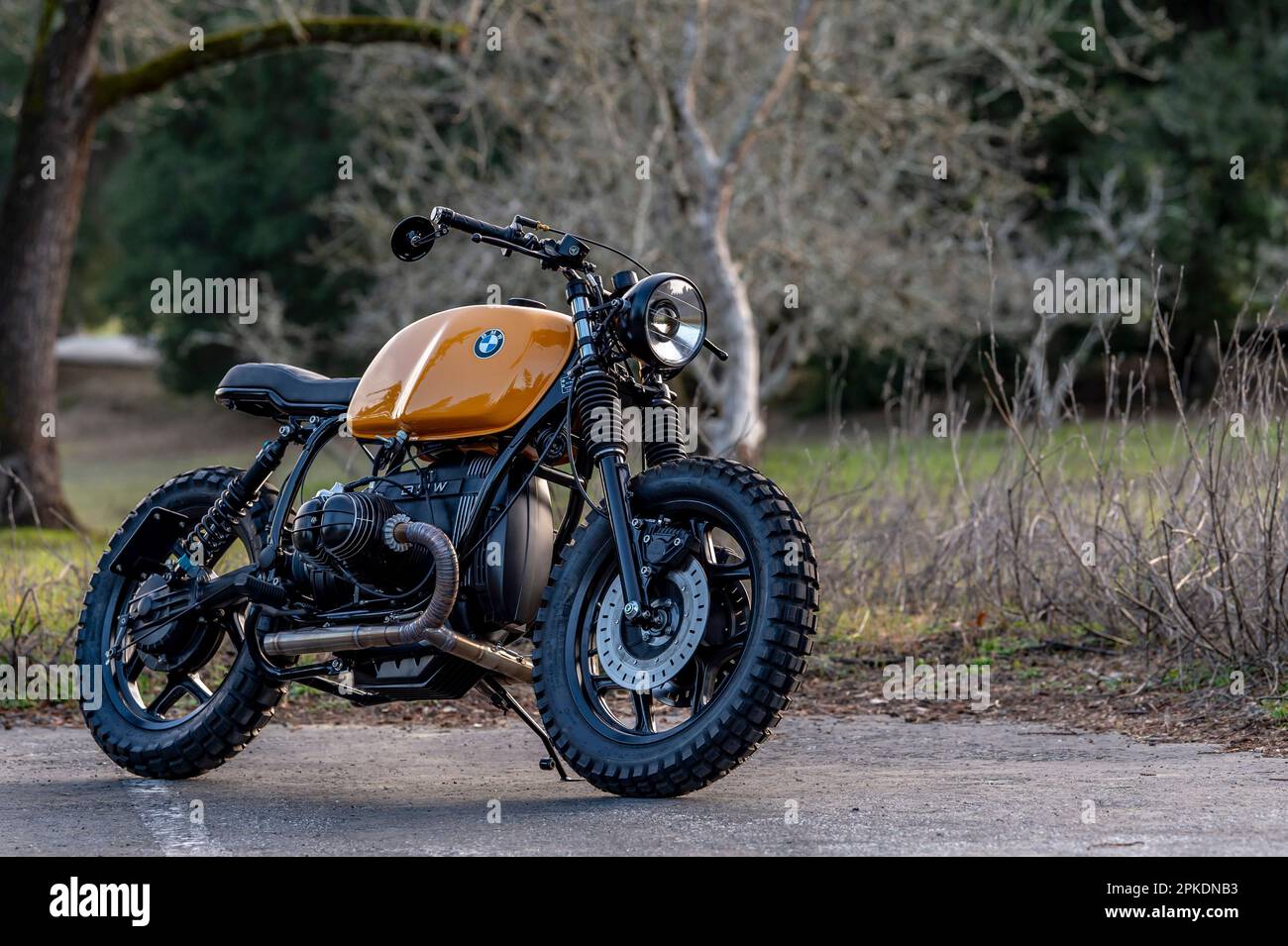 A vintage brown BMW motorcycle with black wheels is parked in a ...