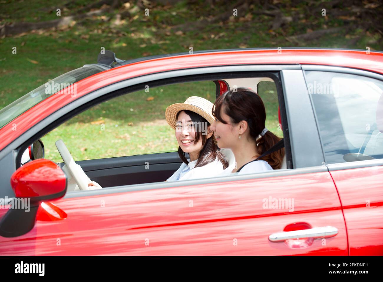 Two women laughing in a red car Stock Photo - Alamy
