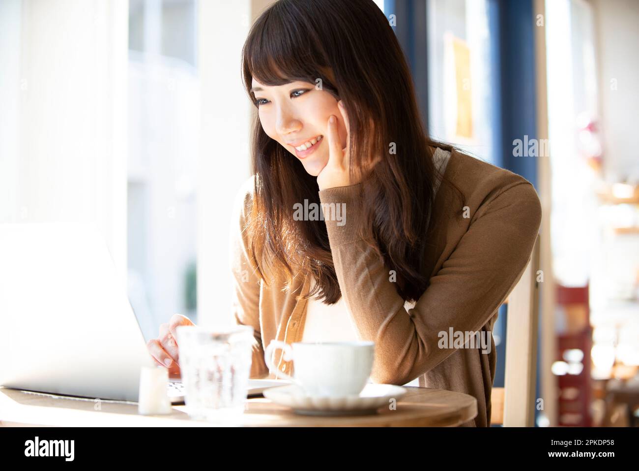 Woman working at a café using a computer Stock Photo