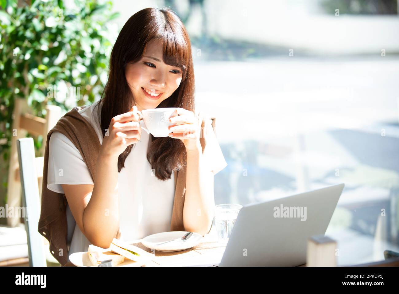 Woman drinking coffee at a cafe Stock Photo
