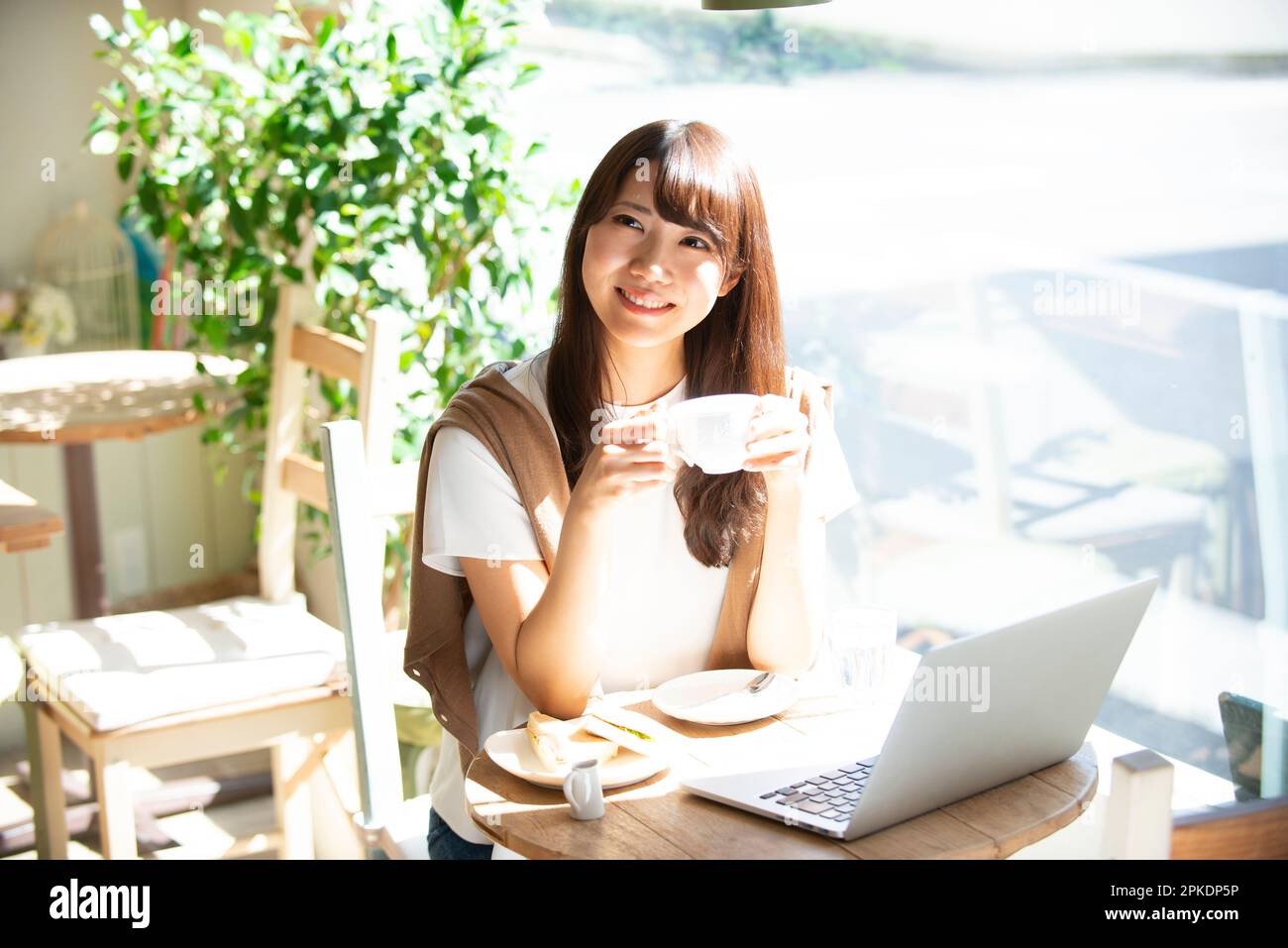 Woman drinking coffee at a café Stock Photo