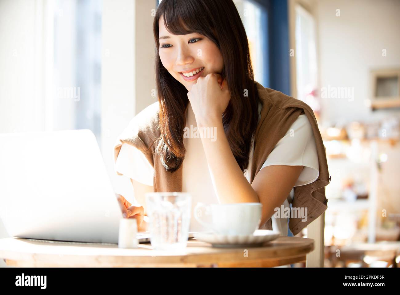 Woman working at a café using a computer Stock Photo