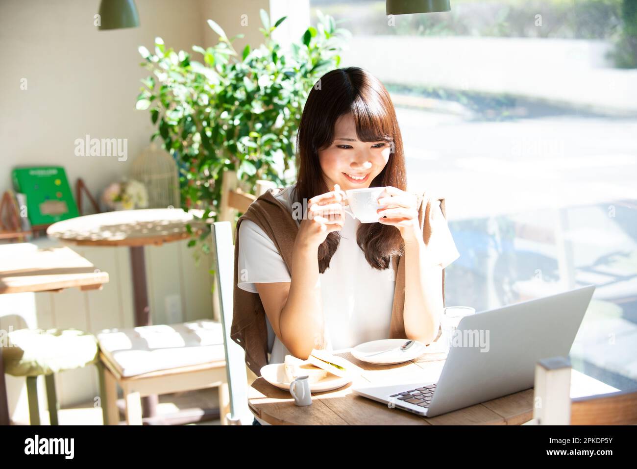 Woman drinking coffee at a cafe Stock Photo