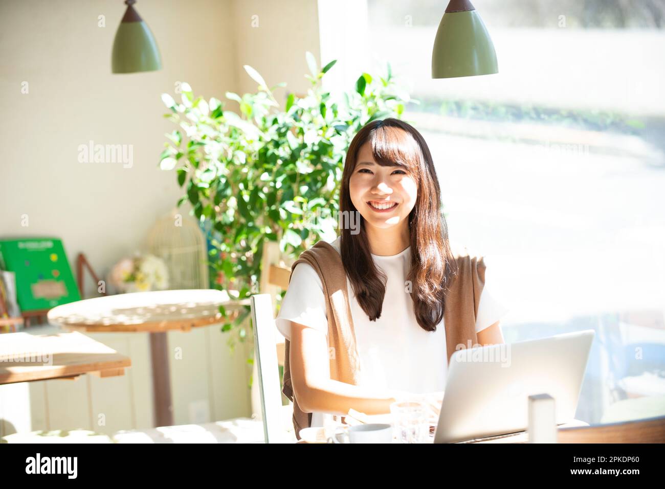 Woman working on a computer at a café Stock Photo