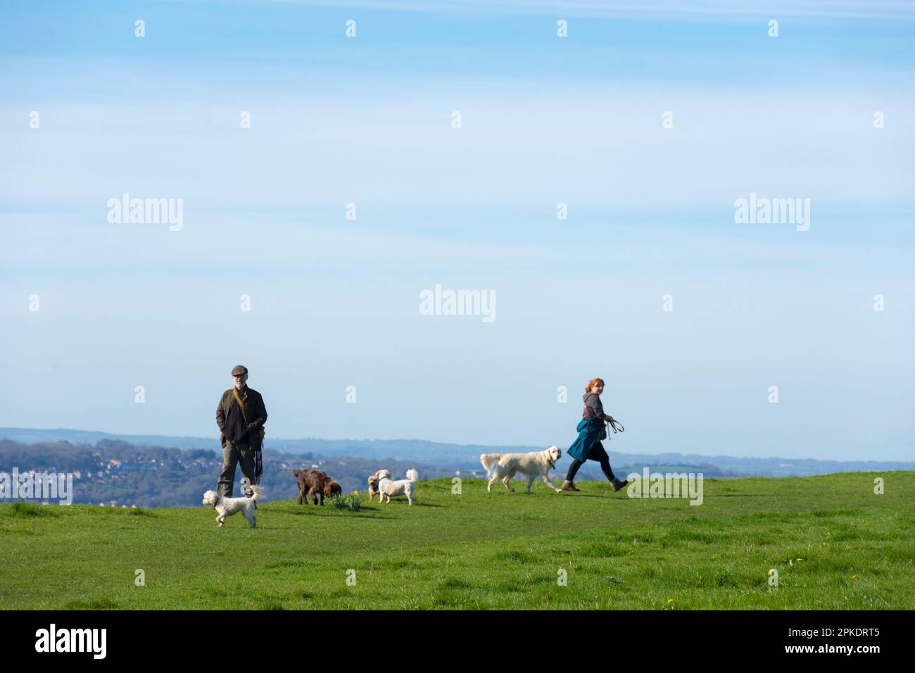 Batheaston, Somerset, UK weather. 7th April 2023. Dog walkers atop Little Solsbury Hill, an old Iron Age fortress hill, on a warm sunny day. Credit: Richard Wayman/Alamy Live News Stock Photo