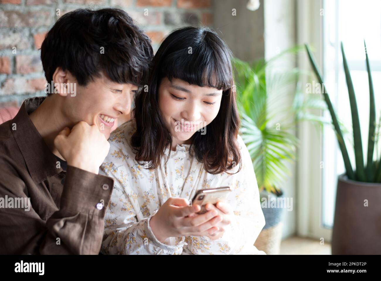 Couple looking at their phones at home Stock Photo