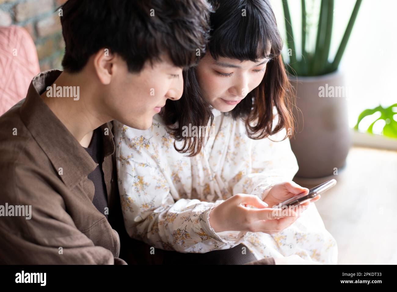 Couple looking at their phones at home Stock Photo